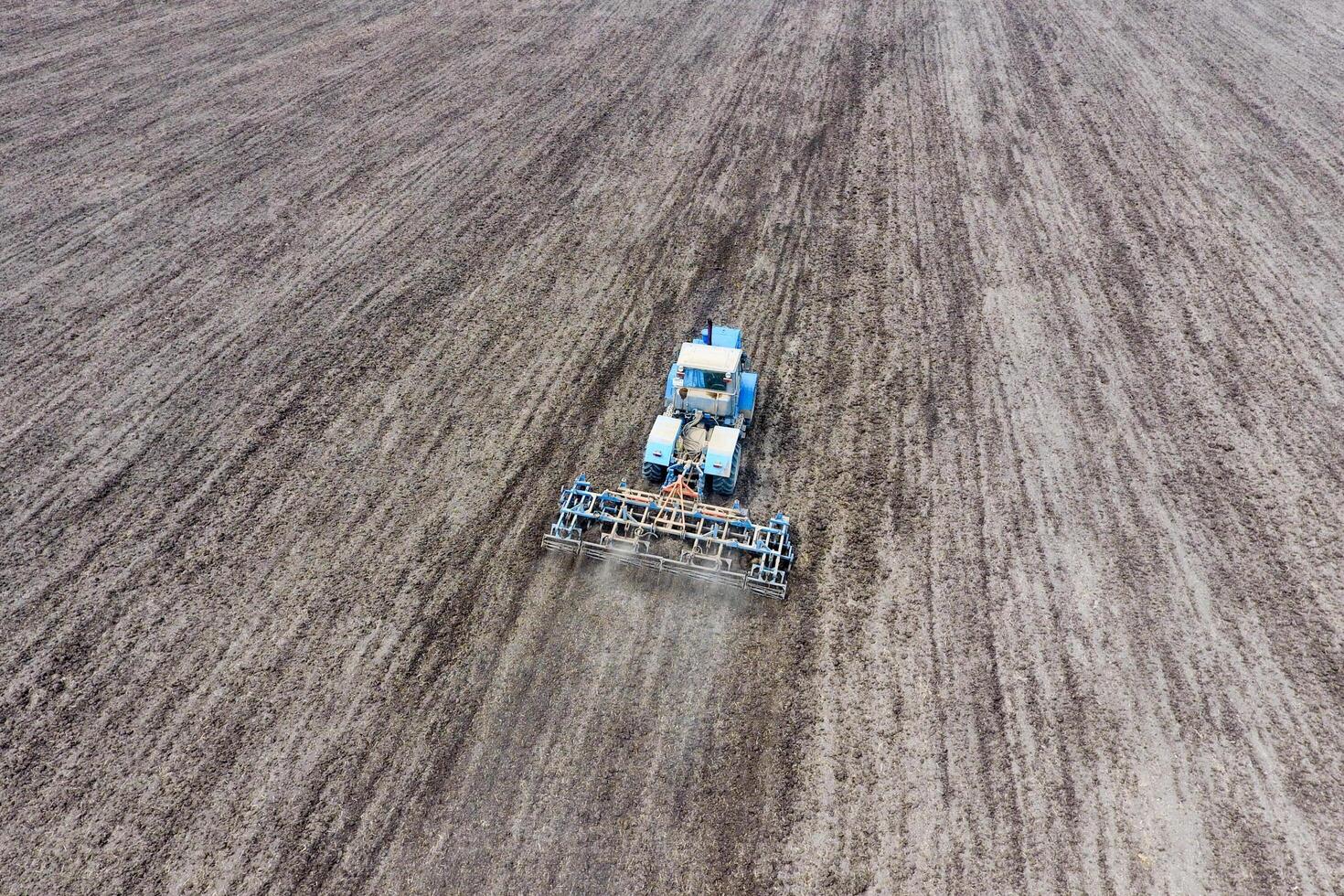 Cultivation of soil for the sowing of cereals. Tractor plows the soil on the field photo