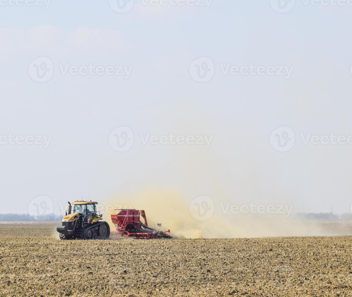 Tractor rides on the field and makes the fertilizer into the soi photo