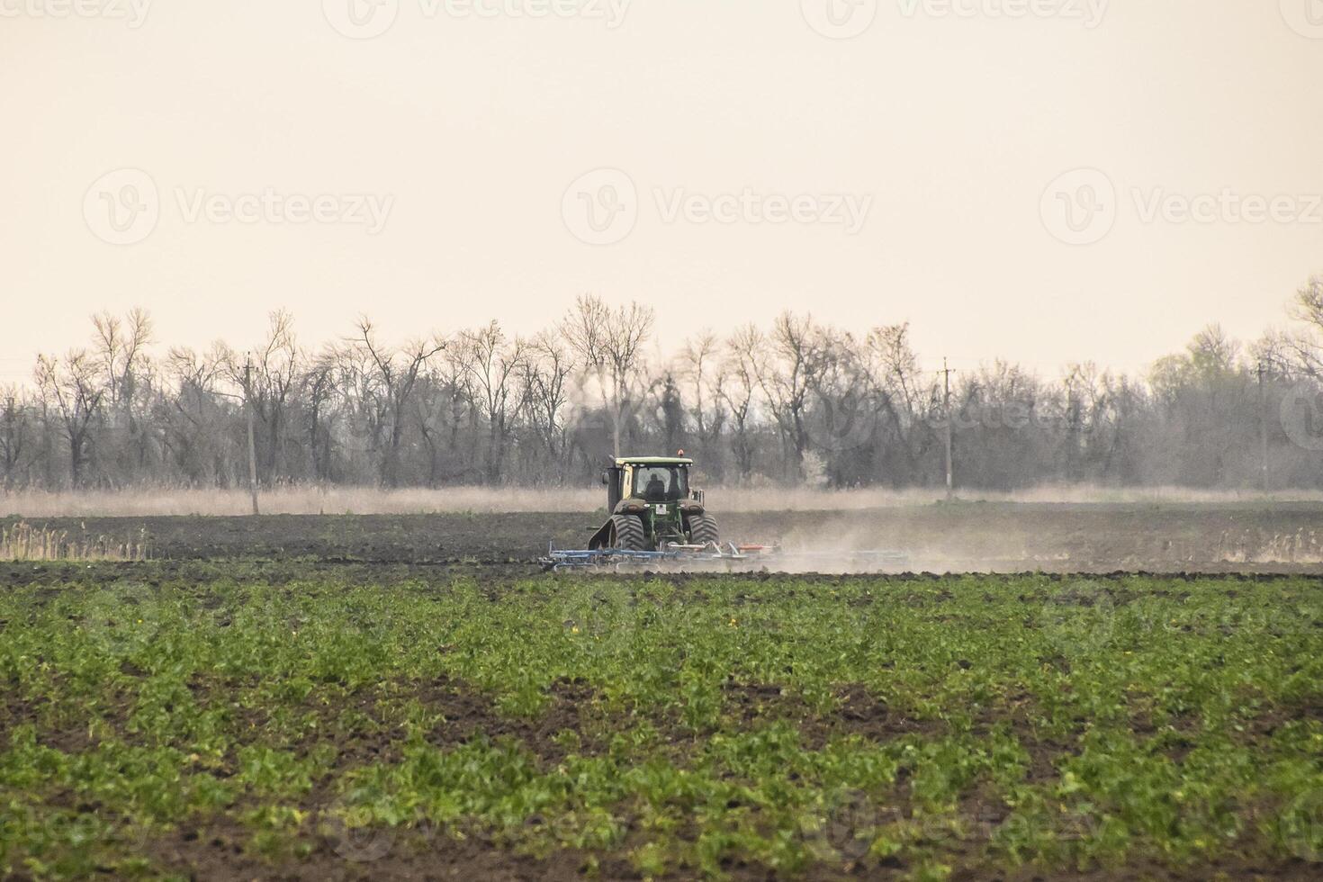 Tractor plowing the soil processes photo
