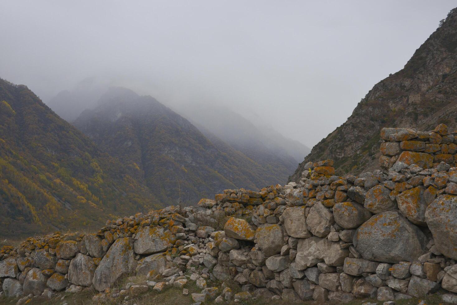 nublado brumoso cielo, montaña picos cubierto con niebla en el Mañana. Cáucaso montañas, Superior balkaria, Rusia. foto
