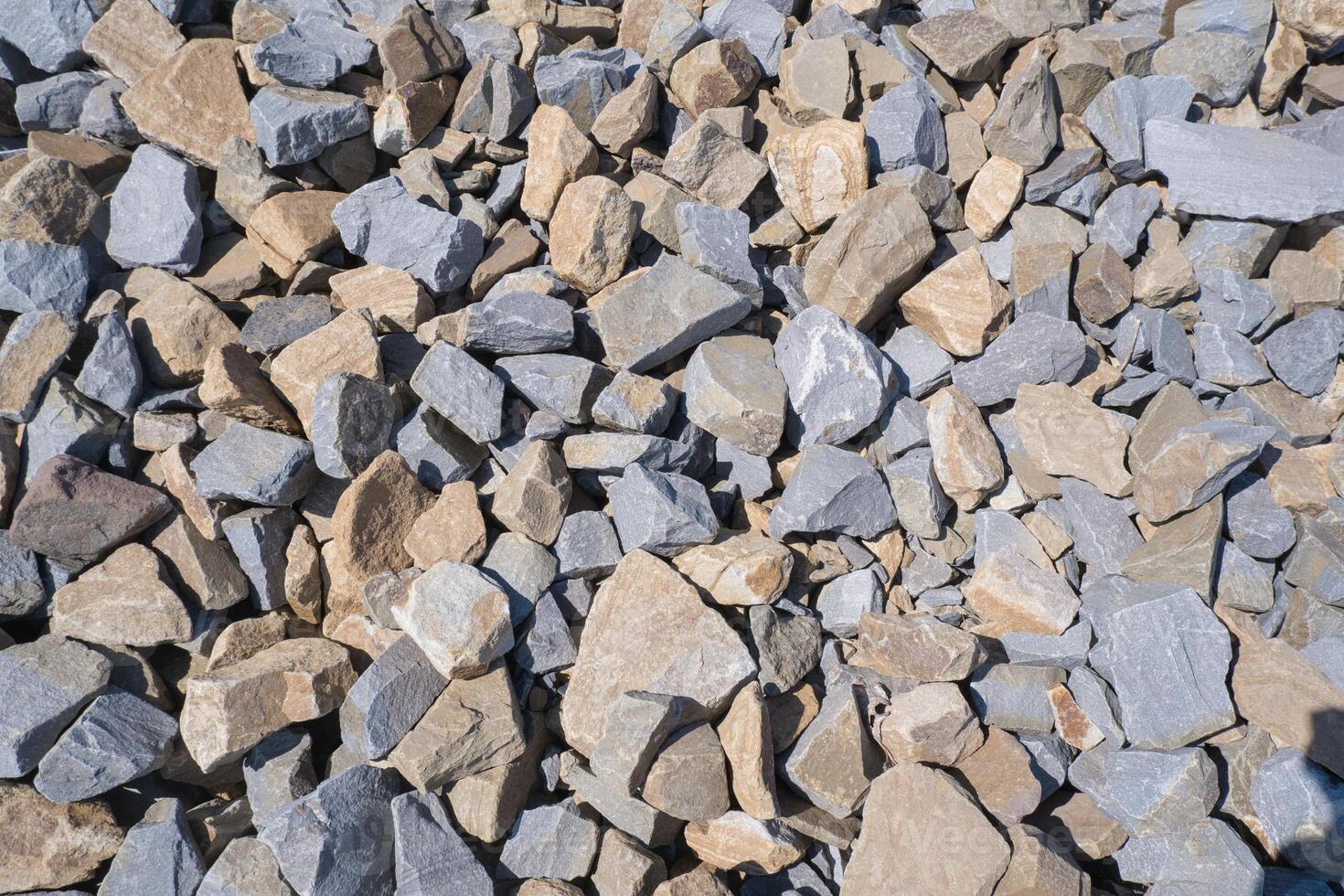 Gravel texture. Pebble stone background. Light grey closeup small rocks. Top view of ground gravel road photo