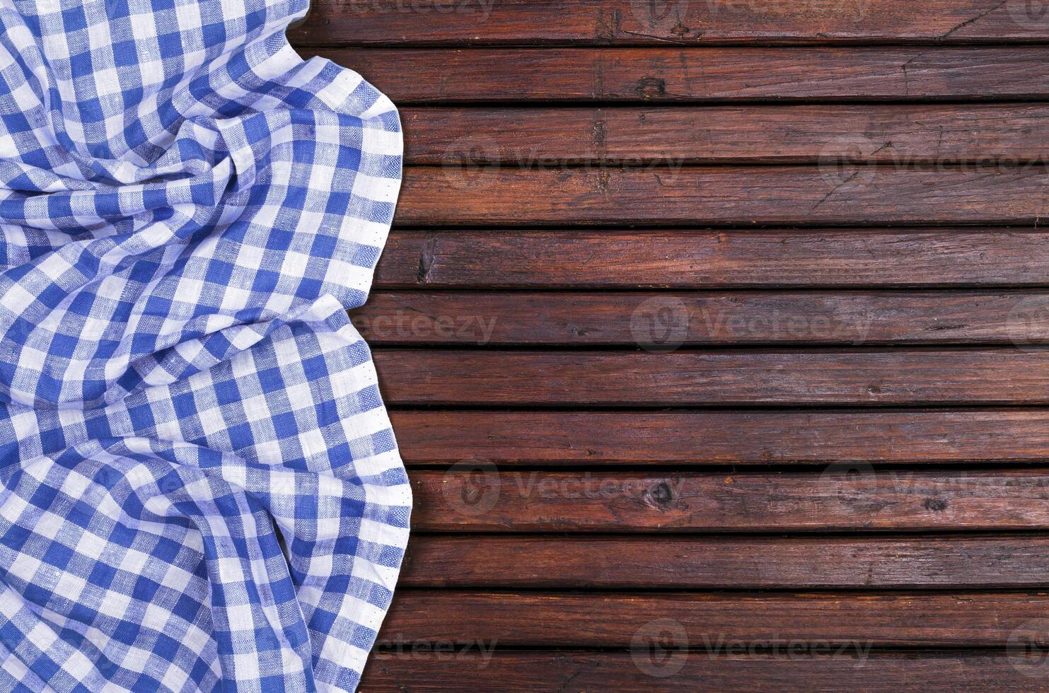 Dark wooden table with blue checkered tablecloth, top view with copy space photo