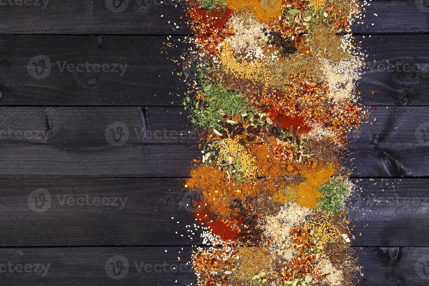 Herbs and spices over black wooden background photo