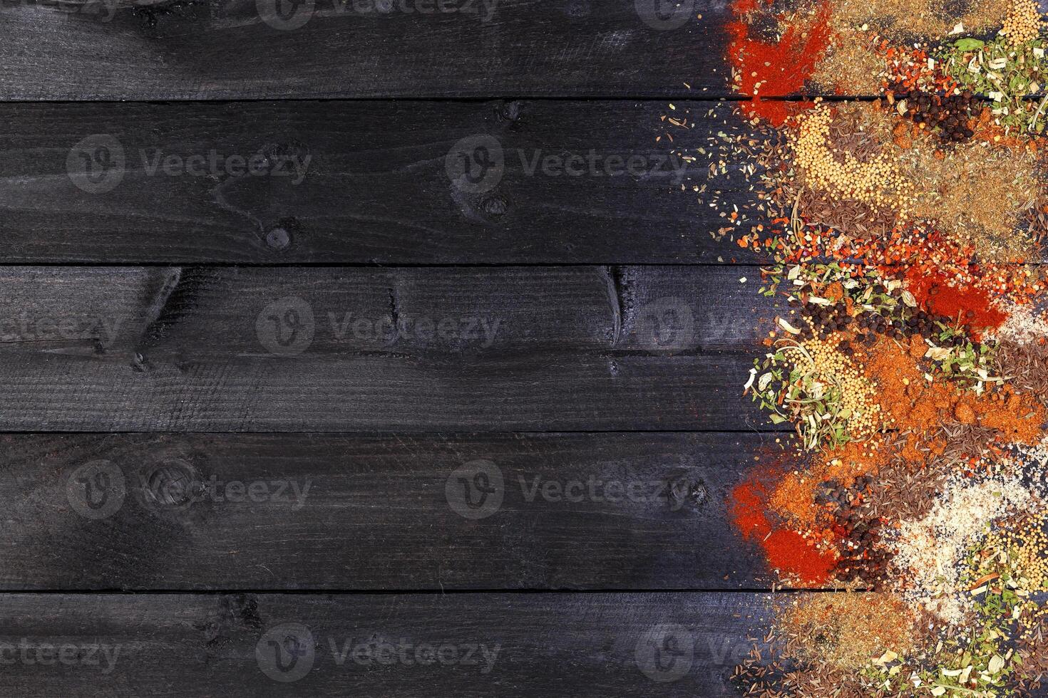 Herbs and spices over black wooden background. Top view with copy space photo