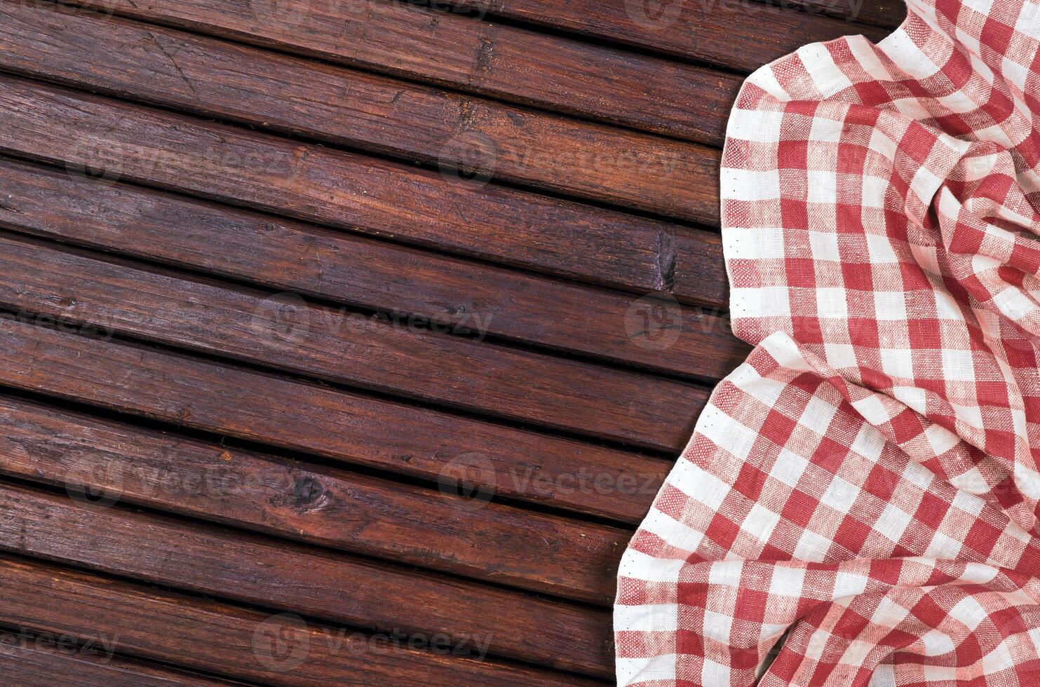 Red checkered tablecloth on dark wooden table with, top view with copy space photo