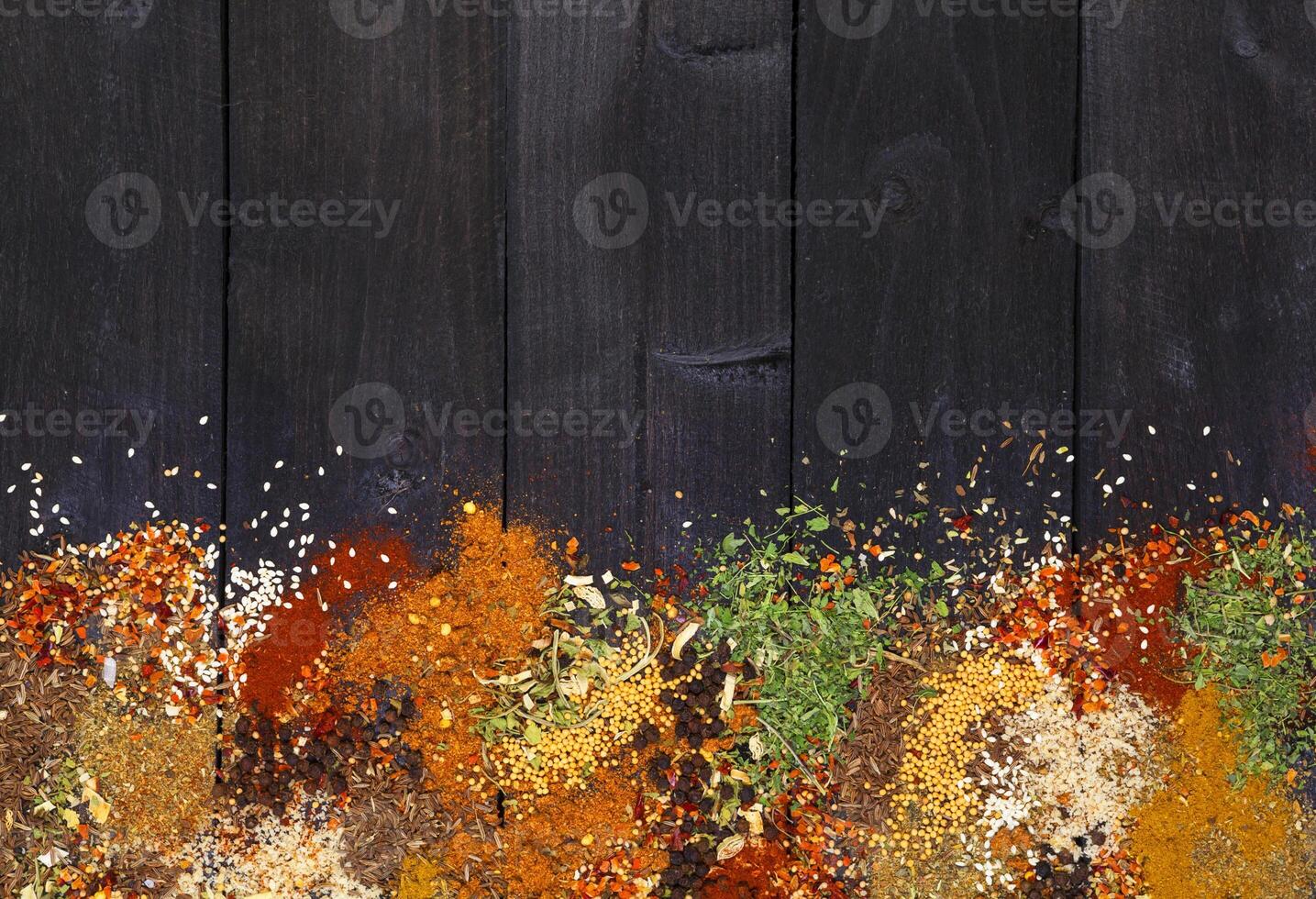 Herbs and spices over black wooden background. Top view with copy space photo