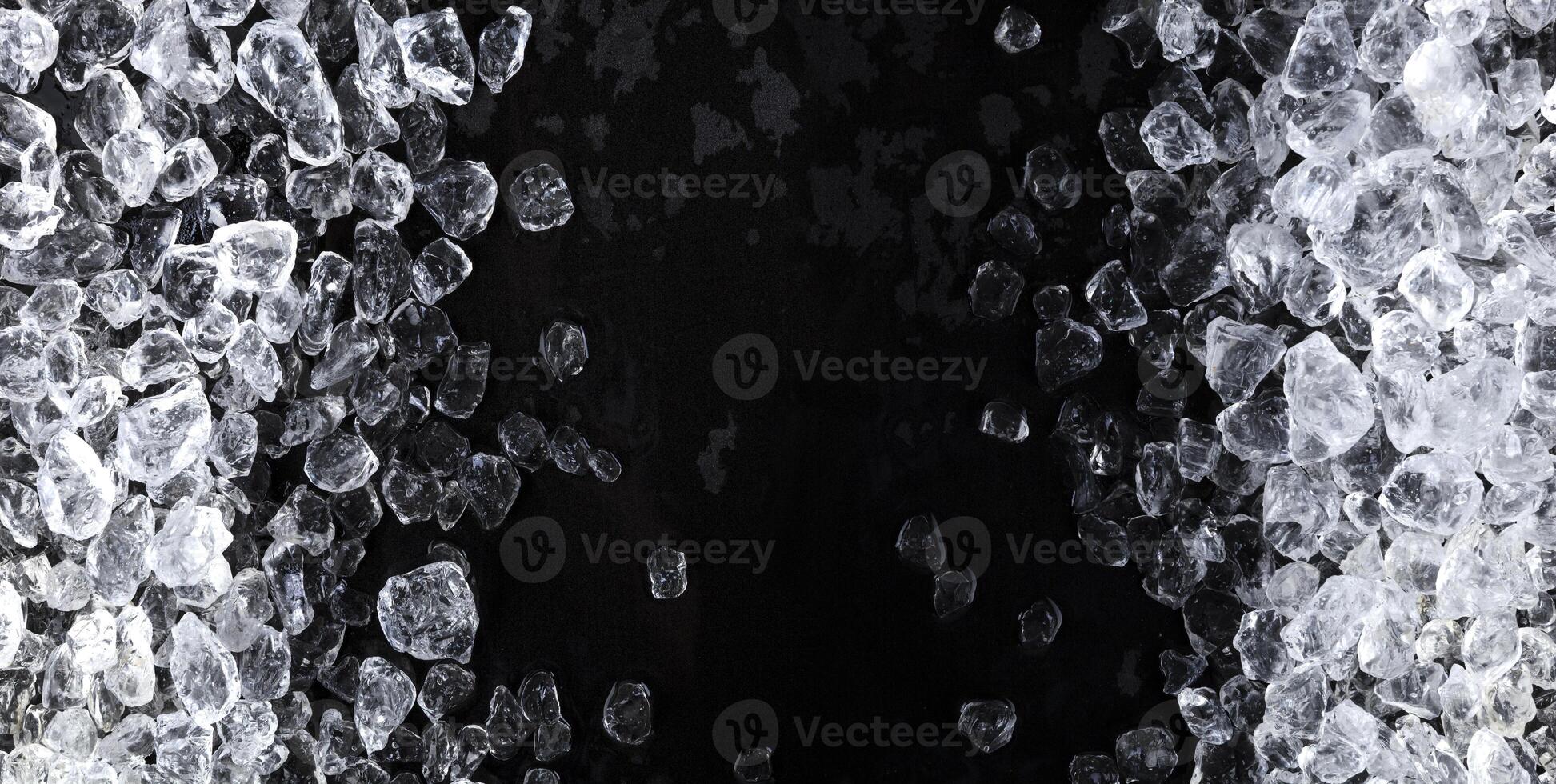 trozos de hielo picado sobre fondo negro foto