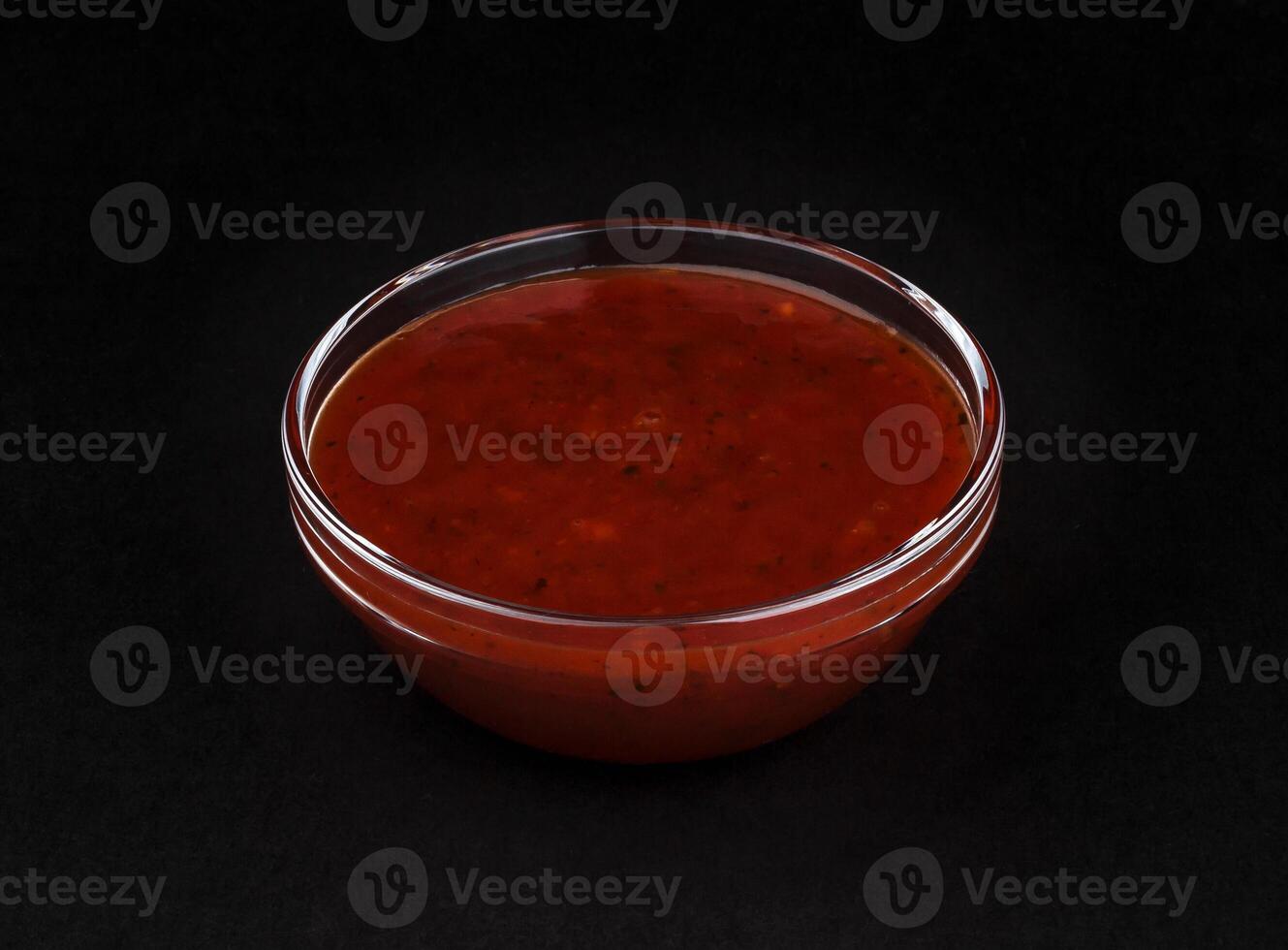 Red sauce isolated on black background photo