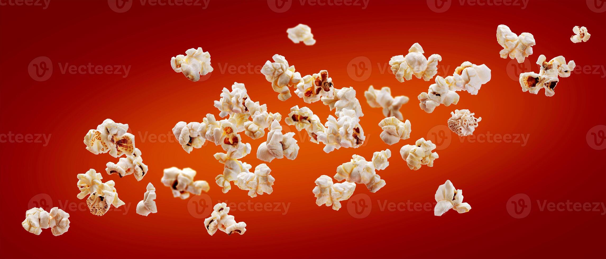 Popcorn isolated on red background. Falling or flying popcorn. Close-up photo