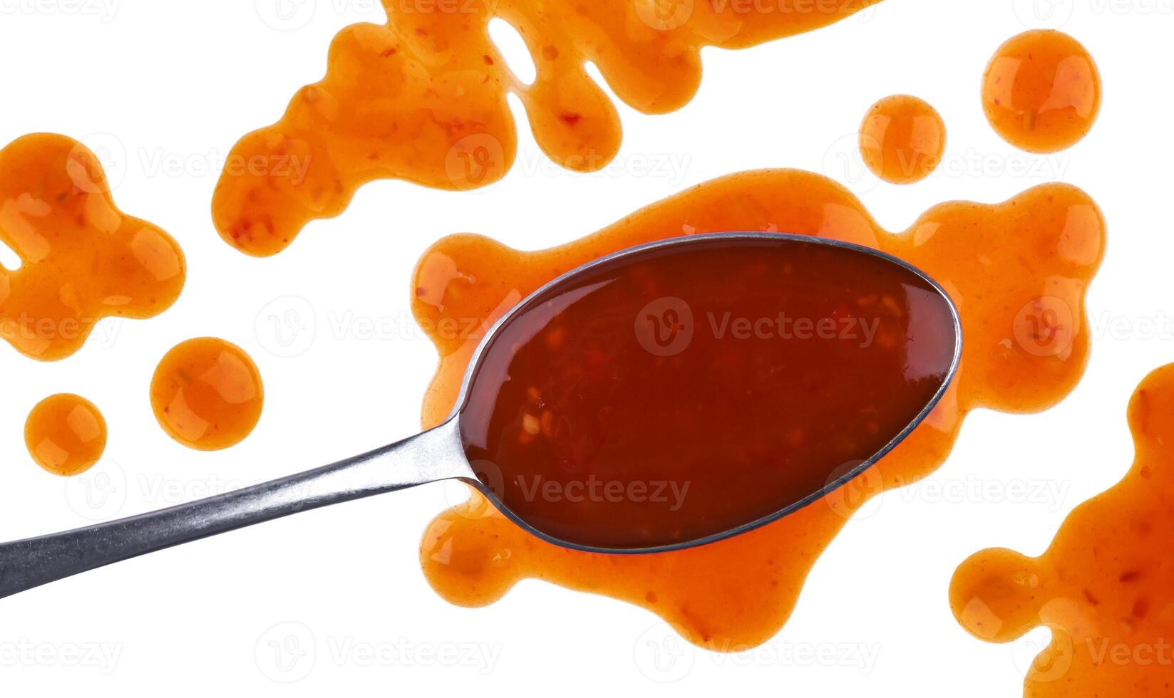 Splach of sweet and sour sauce with spoon isolated on white background. Top view photo