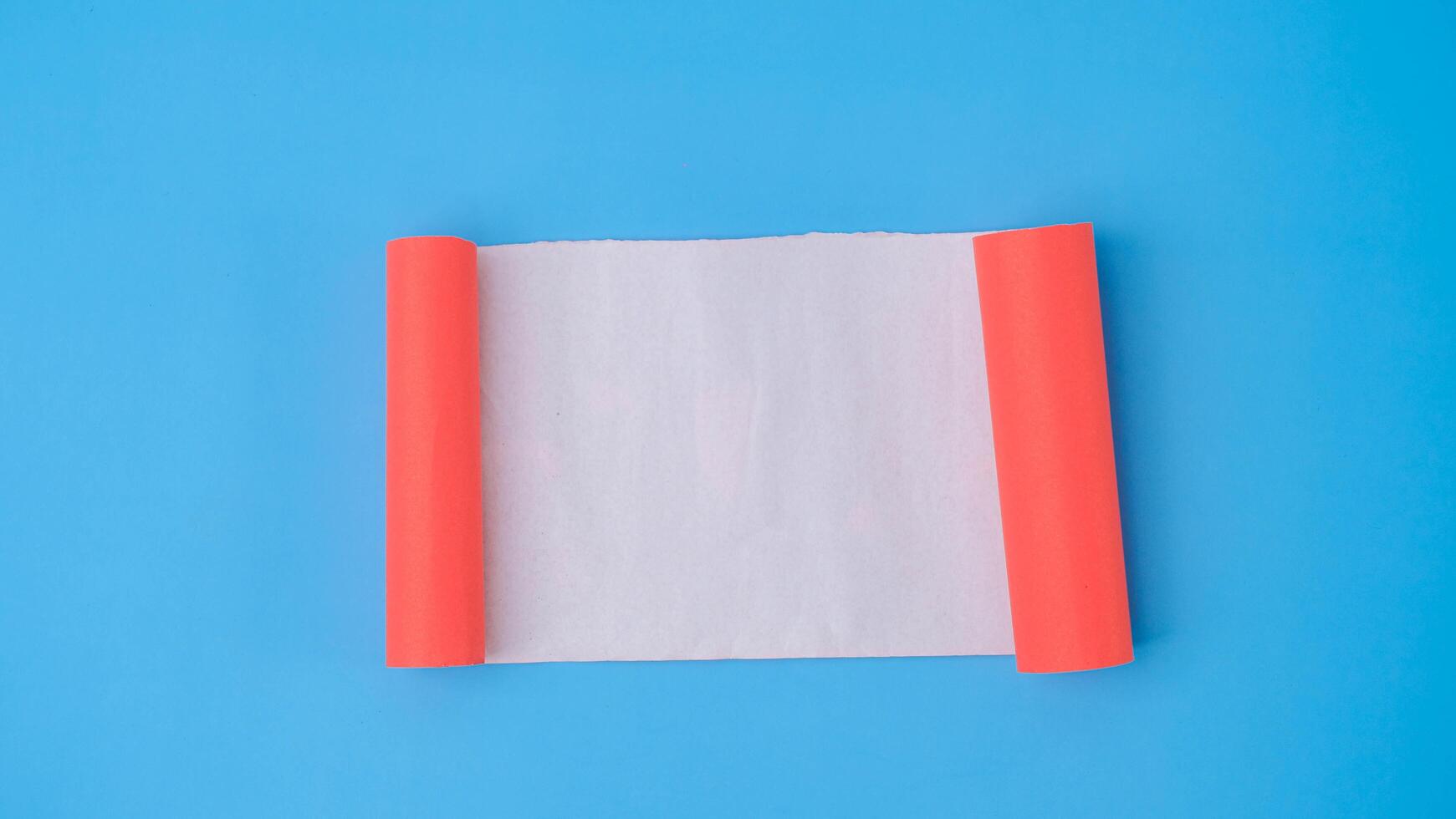 An orange rolled square paper is spread out into a blank white sheet on a light blue background. Crumpled blank white paper with copy space for text or advertising space. photo