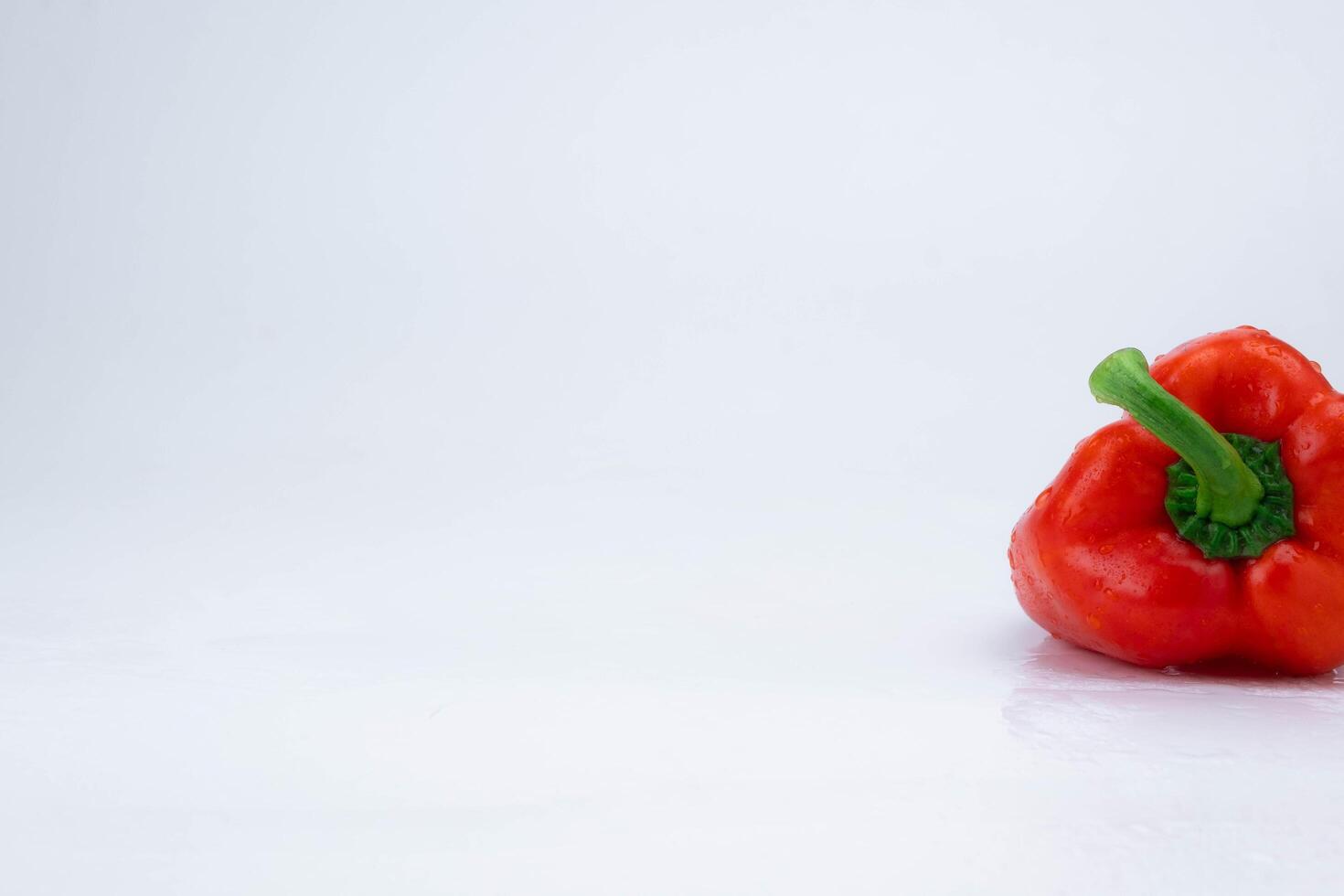 Fresh red bell pepper with water drops isolated on white background. photo