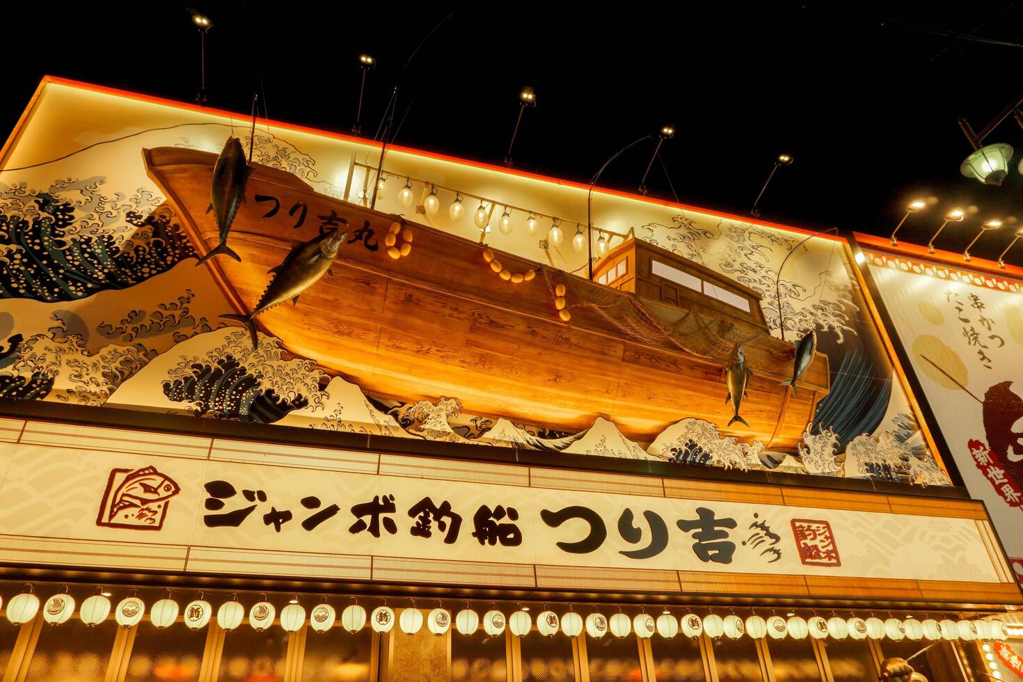 Osaka, Japan, 2023 -Japanese restaurant sign letters and ocean wave drawing with wooden ancient Japanese fishing boat carving, One of beautiful restaurant sign at Shinsekai area of Osaka city. photo