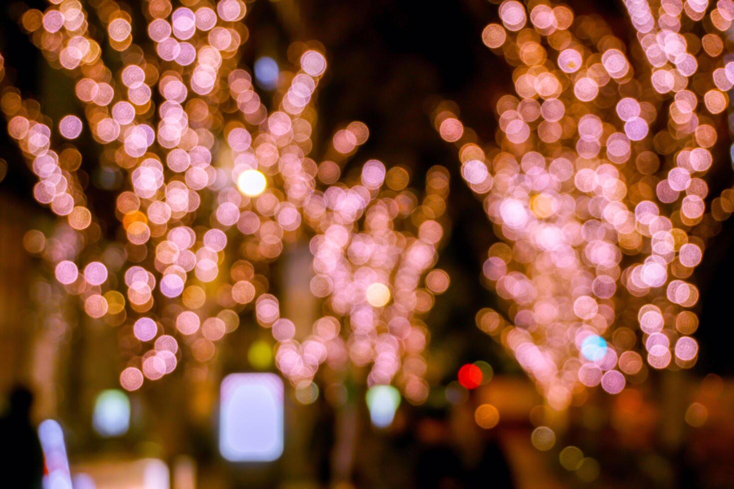 Closeup blurred and bokeh of pink LED refection lighting decorate on trees in Valentines day with city night life in Osaka, Japan. photo