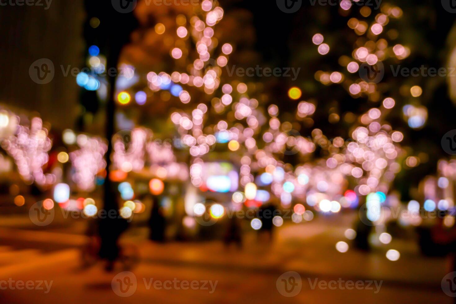 Blurred and bokeh of pink LED refection lighting decorate on trees in Valentines day with city night life in Osaka, Japan. photo