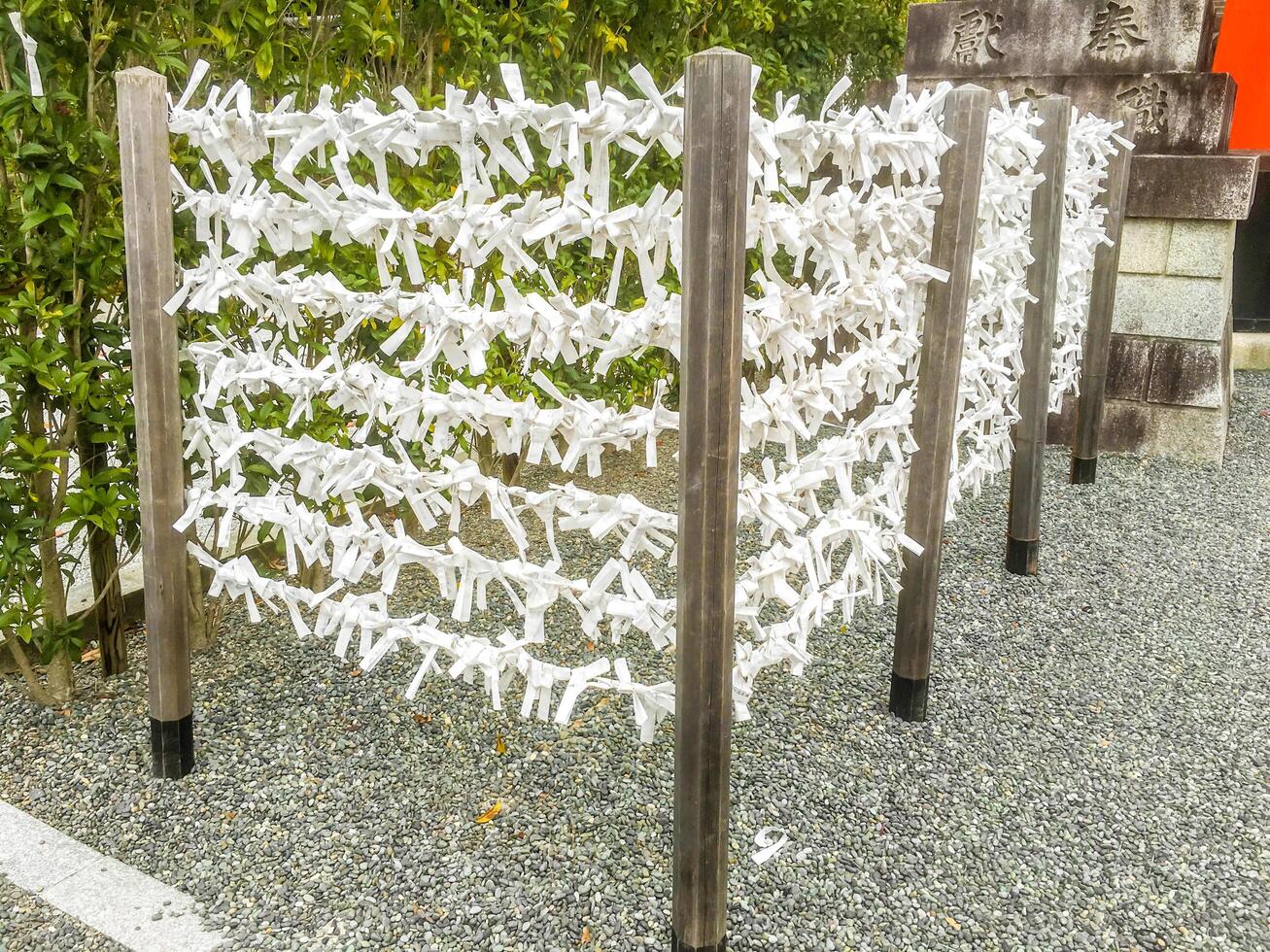 Nara City, Japan, 2023 - Japanease Omikuji random fortunes paper tied to rope wire for good luck at Kasuga Japanese shrine in Nara city. photo