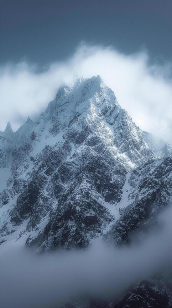 ai generado majestuoso Nevado montaña pico enmarcado por nubes en un sereno paisaje vertical móvil fondo de pantalla foto