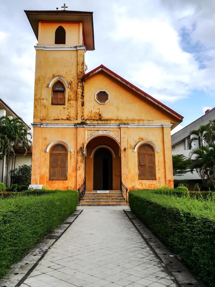 Trang City, THAILAND, 2018 - Front of yellow historic Christian church age over 100 years old and is one of 20 historic sites popular of tourist in Trang Province, Thailand. photo