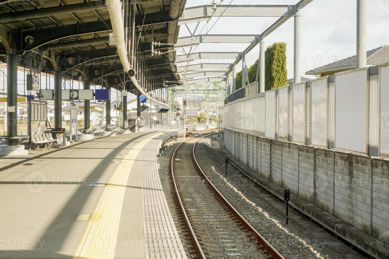 Outdoor train platform and railroad track on sunny day. photo