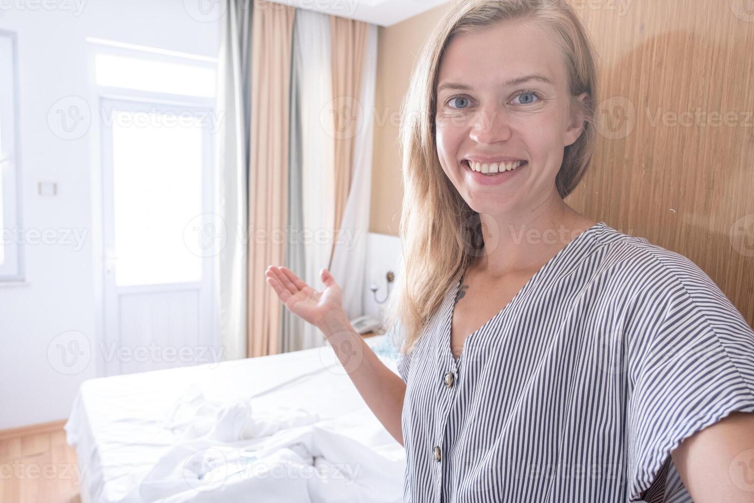 Happy woman showing her hotel room taking selfie photo