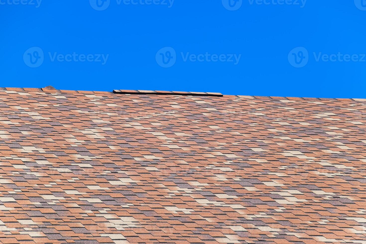 Roof from multi-colored bituminous shingles. Patterned bitumen shingles. photo