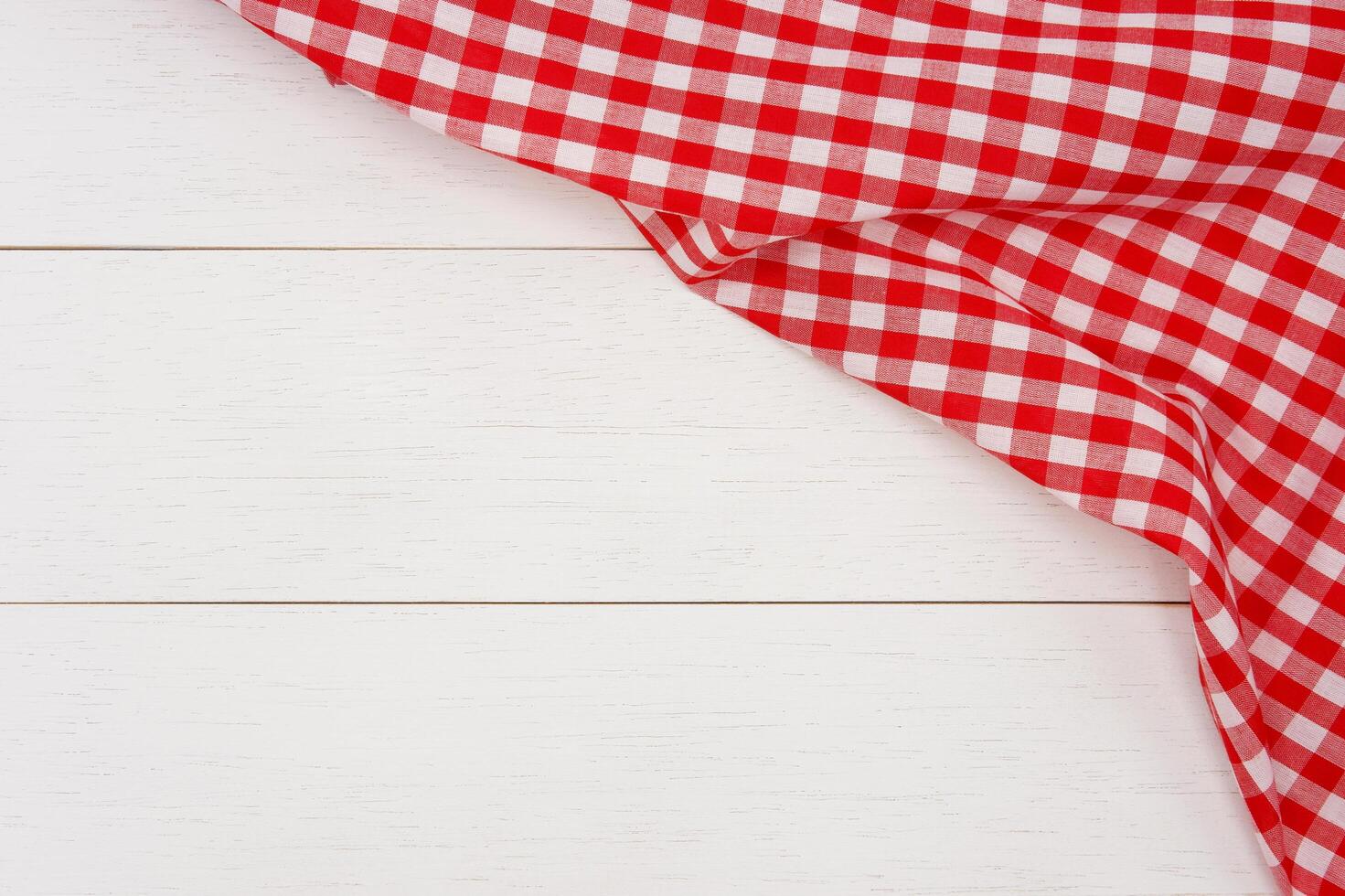 Wrinkled red gingham fabric on rustic white wood plank background, with copy space. photo