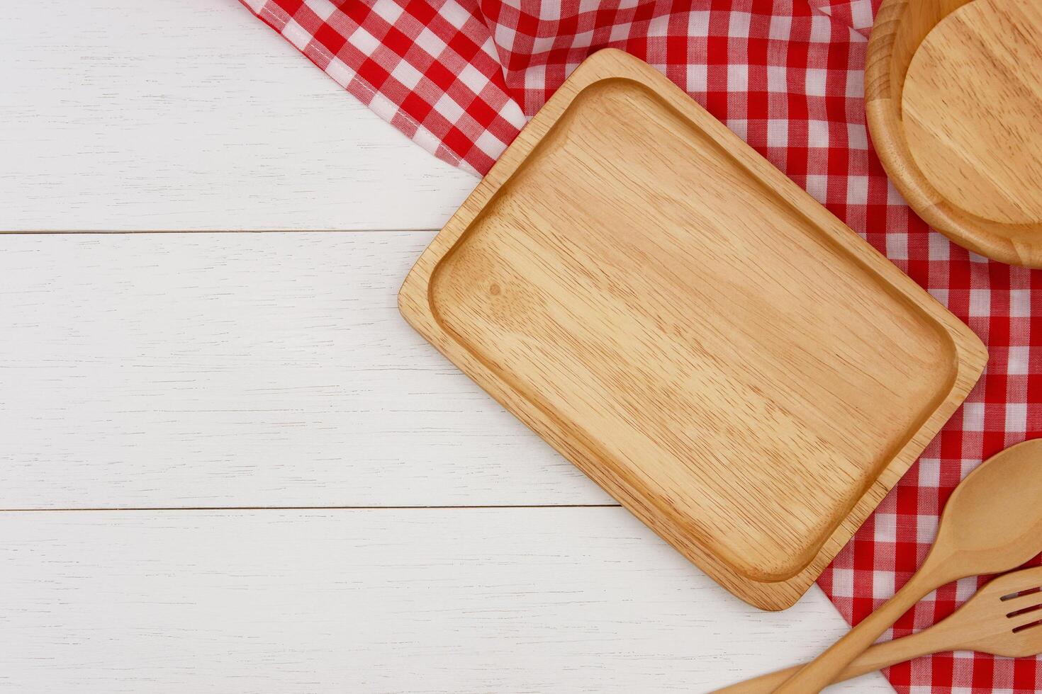 Empty rectangle wooden plate with spoon and fork on white wooden table. Top view image. photo