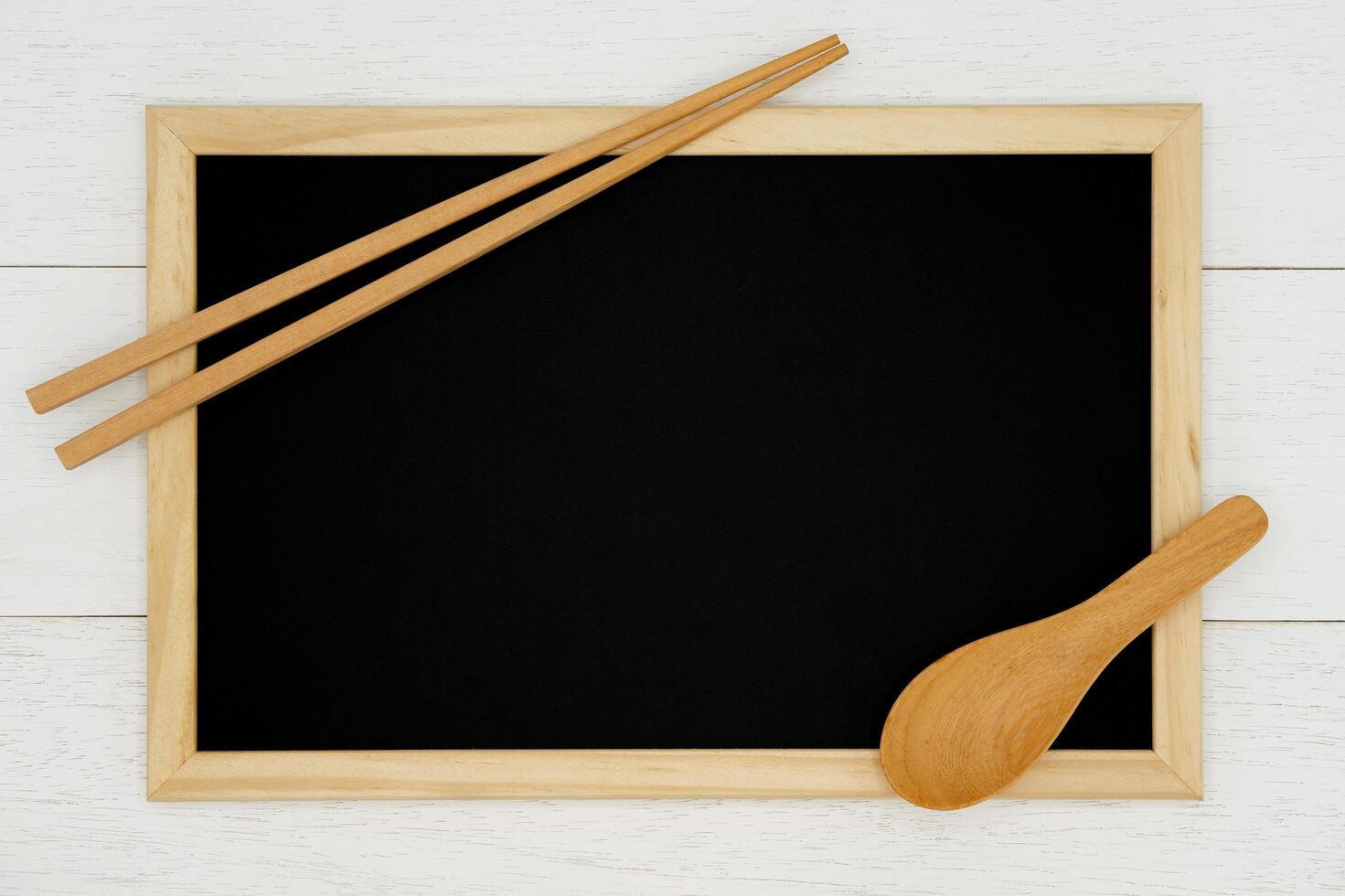 Blank chalkboard with wooden spoon and chopsticks on white wood plank background. Styled stock photography for cookbook, food blog posts and social media content. photo