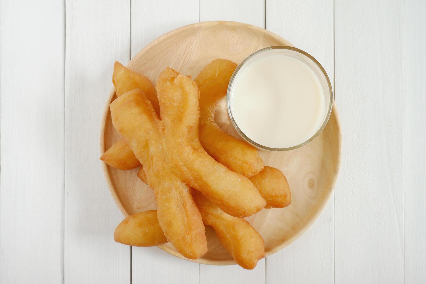 Pa Tong Go, Thai style Chinese crullers in wooden plate on white wooden background. top view with copy space. photo