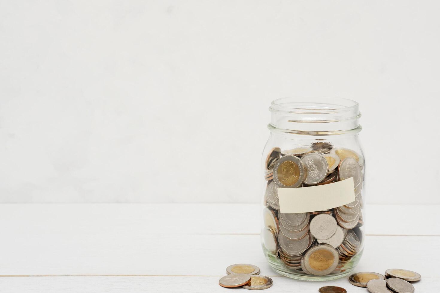 Thai Baht coins in a glass jar. Business and finance concept. photo