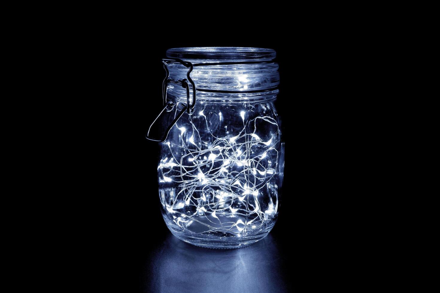 White fairy light in a glass jar, in the dark, low-key photography photo