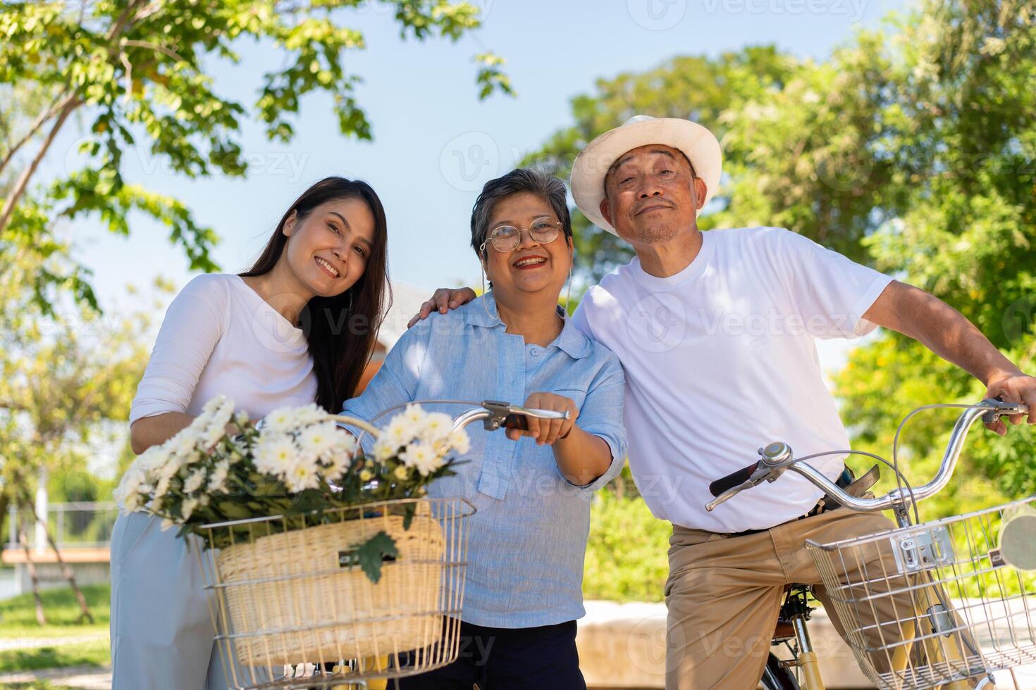 Happy and healthy Asian family standing beside a bicycle after workout together.  friendship lifestyle, Enjoyment of active seniors, outdoor activity after retirement, health care insurance concept. photo