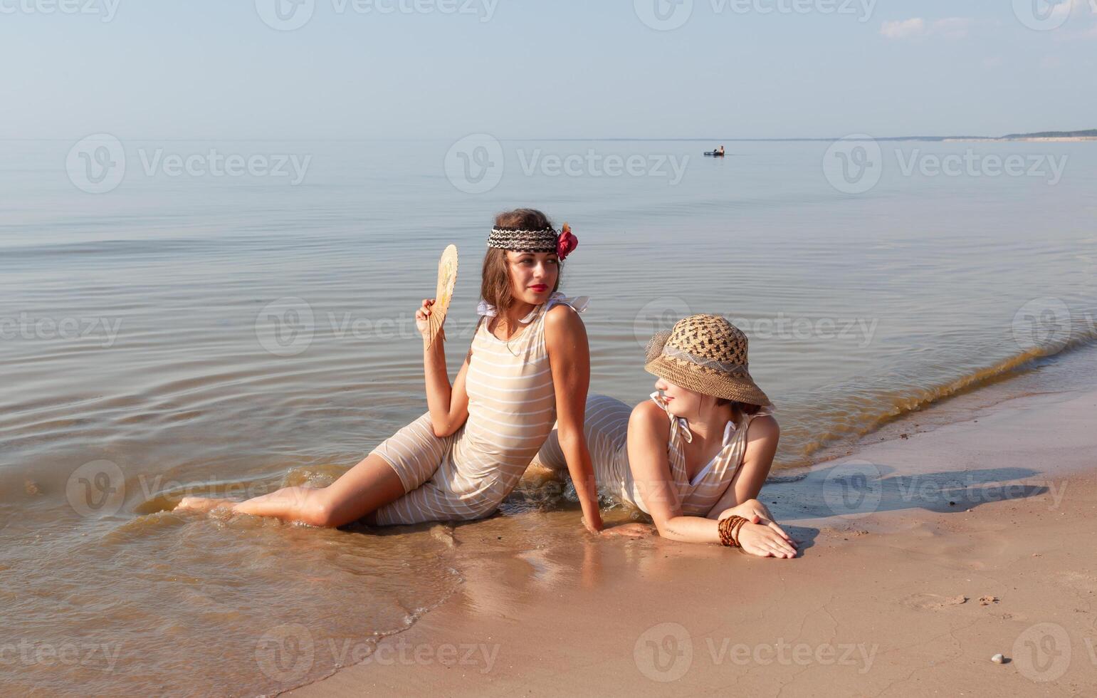 dos joven mujer en retro trajes de baño por el mar foto