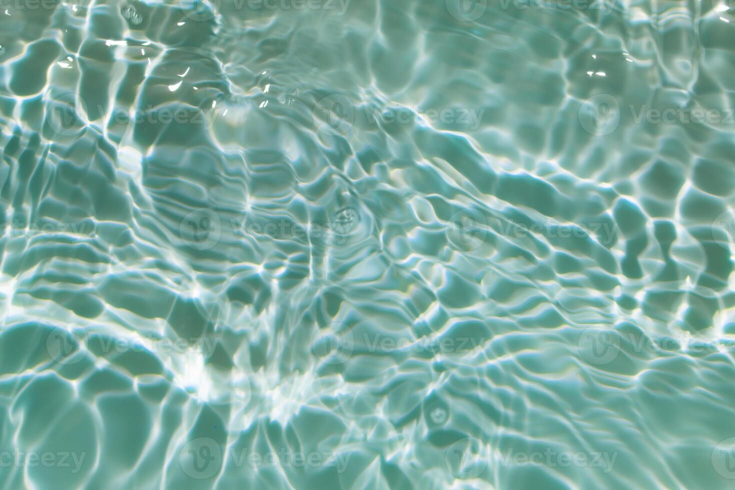 Bluewater waves on the surface ripples blurred. Defocus blurred transparent blue colored clear calm water surface texture with splash and bubbles. Water waves with shining pattern texture background. photo