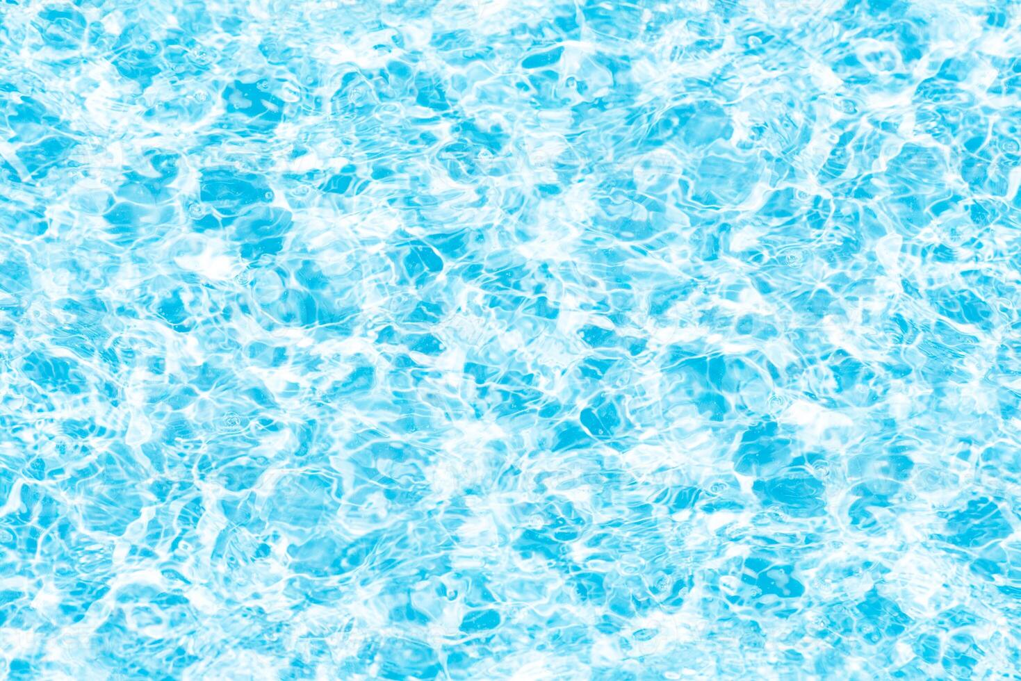 Bluewater waves on the surface ripples blurred. Defocus blurred transparent blue colored clear calm water surface texture with splash and bubbles. Water waves with shining pattern texture background. photo