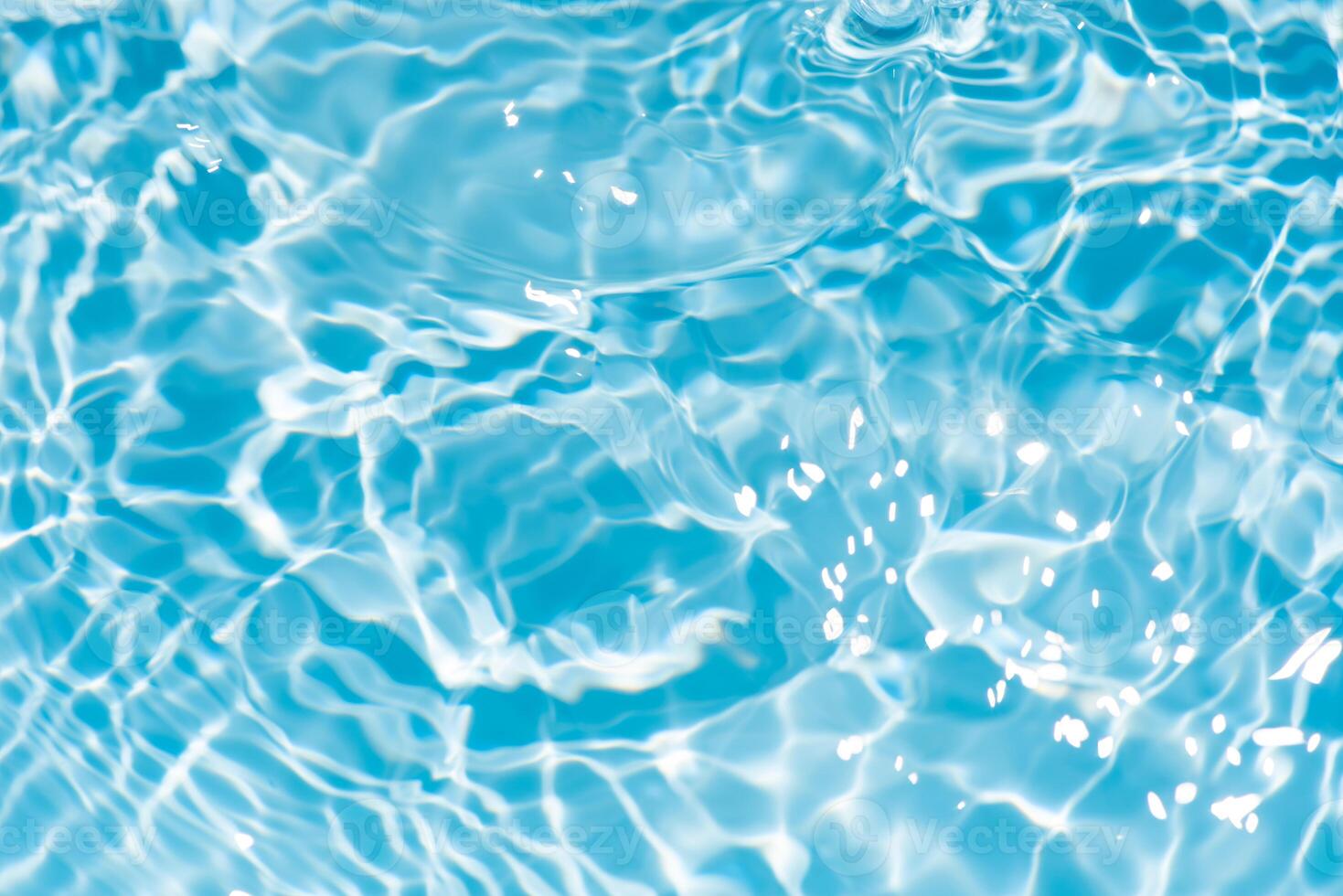 Water surface. Bluewater waves on the surface ripples blurred. Defocus blurred transparent blue colored clear calm water surface texture with splash and bubbles. Water waves with shining pattern. photo