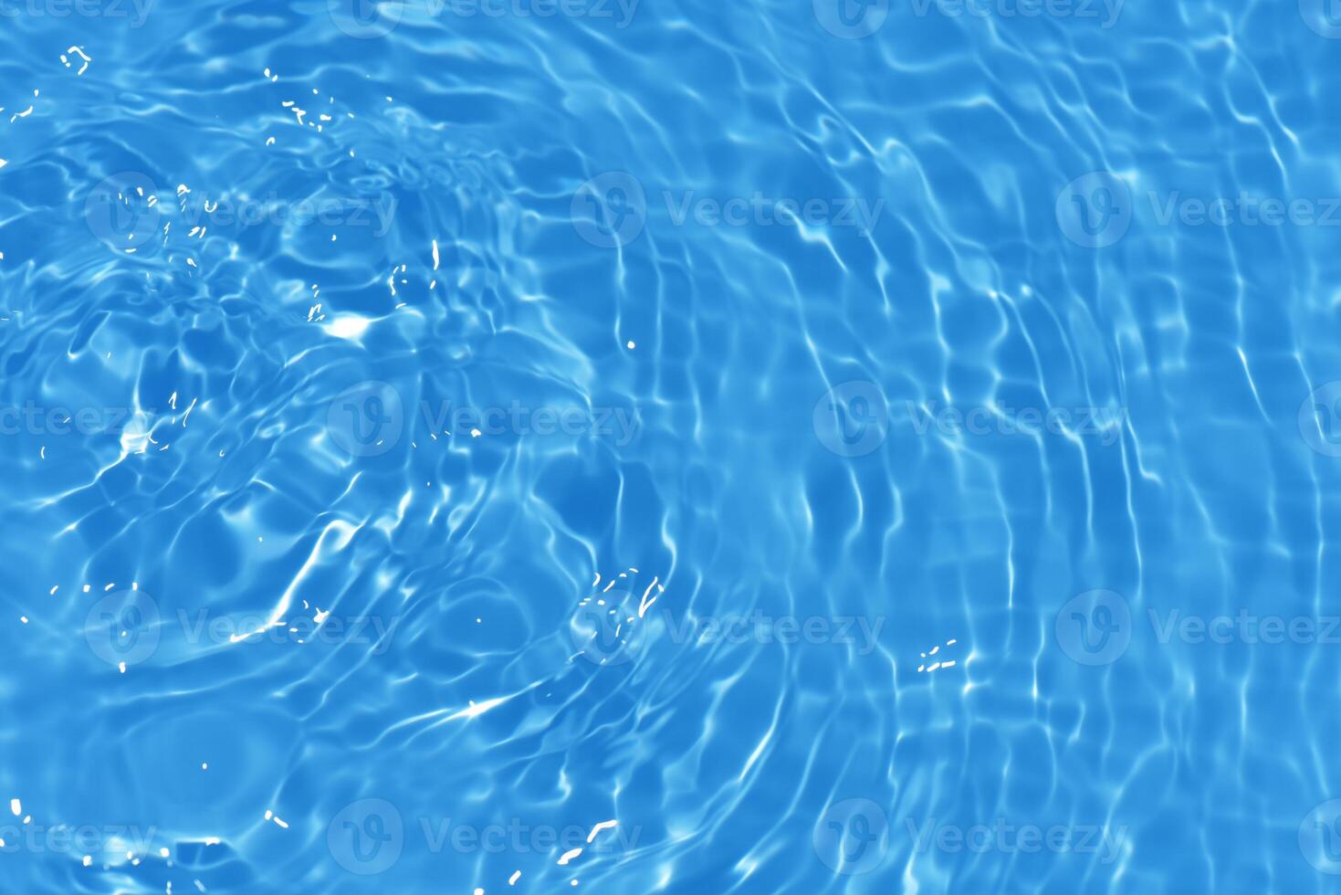 Bluewater waves on the surface ripples blurred. Defocus blurred transparent blue colored clear calm water surface texture with splash and bubbles. Water waves with shining pattern texture background. photo