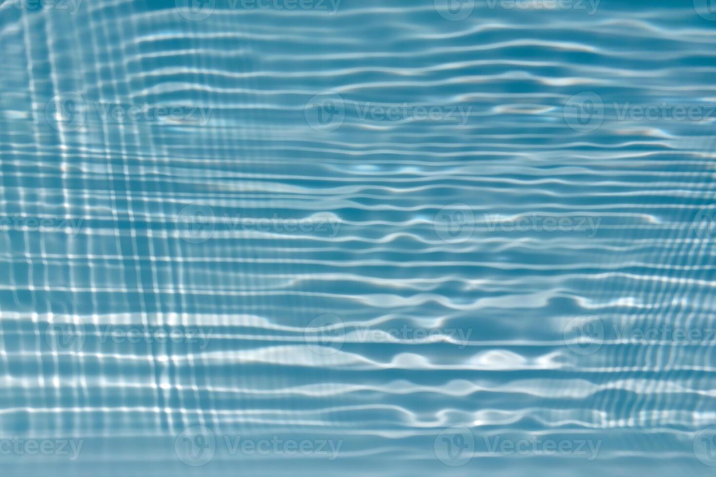 Bluewater waves on the surface ripples blurred. Defocus blurred transparent blue colored clear calm water surface texture with splash and bubbles. Water waves with shining pattern texture background. photo