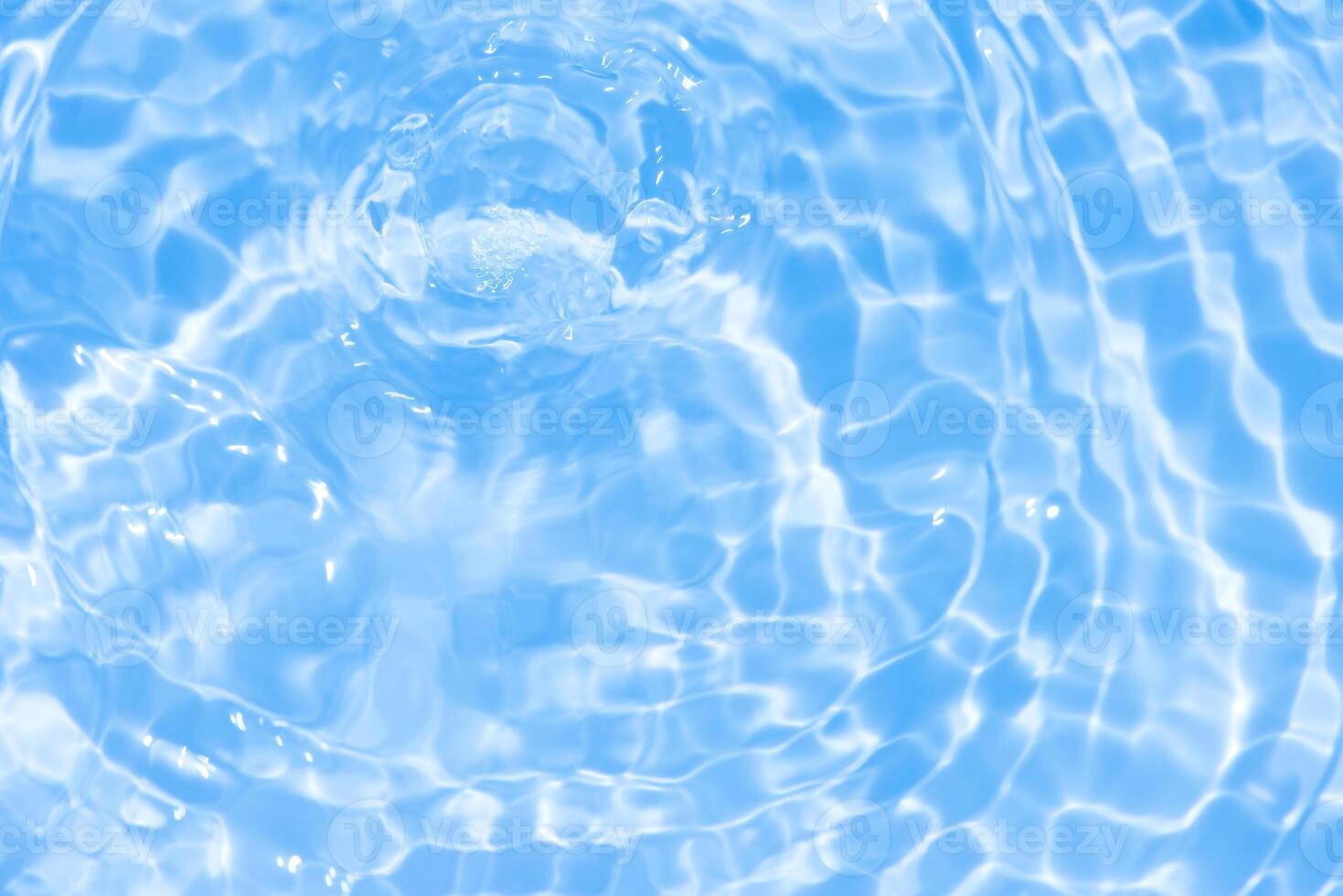 Bluewater waves on the surface ripples blurred. Defocus blurred transparent blue colored clear calm water surface texture with splash and bubbles. Water waves with shining pattern texture background. photo