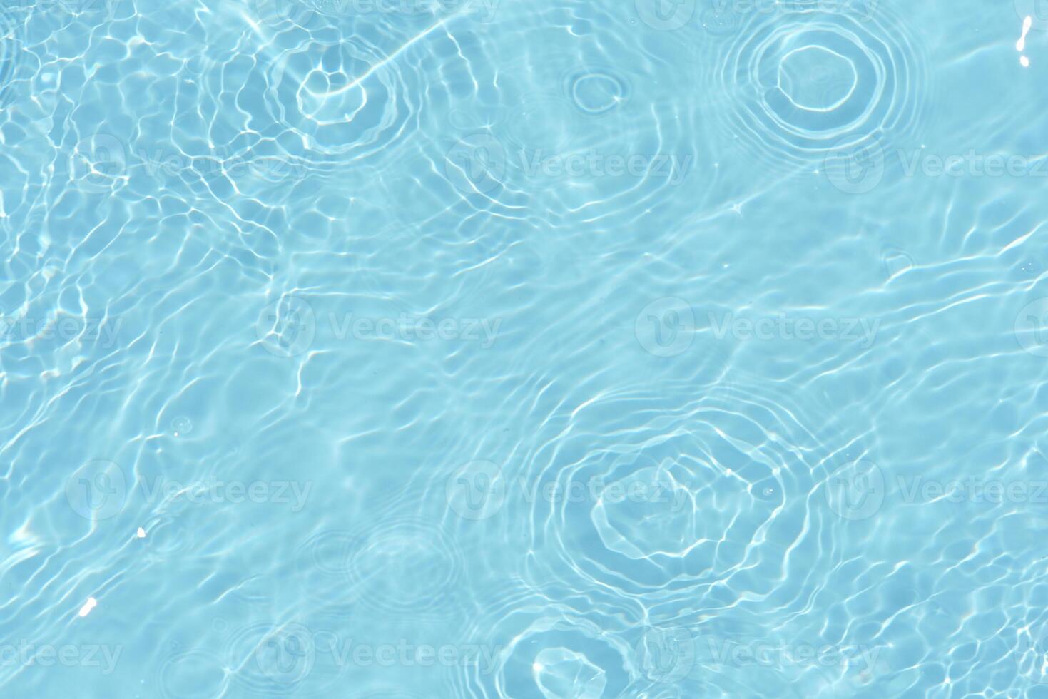Bluewater waves on the surface ripples blurred. Defocus blurred transparent blue colored clear calm water surface texture with splash and bubbles. Water waves with shining pattern texture background. photo