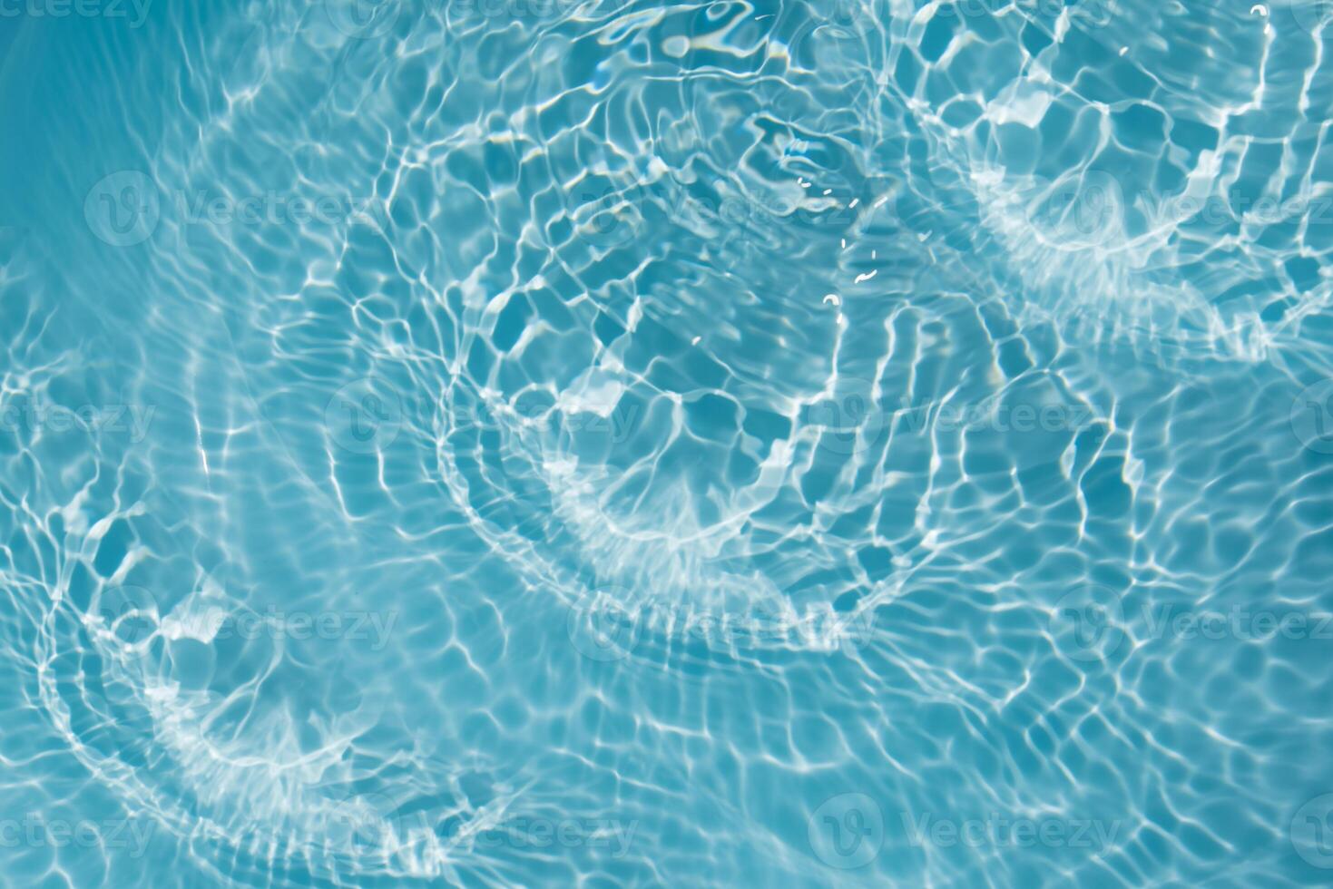 Bluewater waves on the surface ripples blurred. Defocus blurred transparent blue colored clear calm water surface texture with splash and bubbles. Water waves with shining pattern texture background. photo