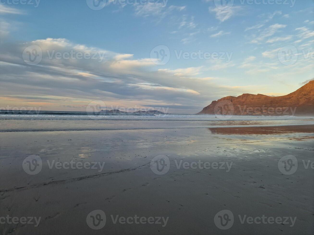 puesta de sol en famara playa en lanzarote isla foto