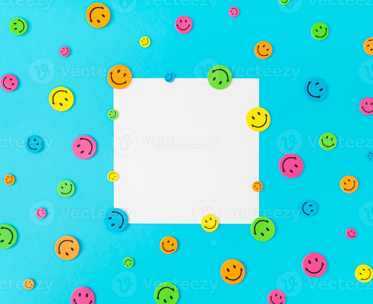Colorful pattern composition made with smiley face stickers on blue background. Minimal positive thinking and good mood concept. Mental health care recovery to happiness emotion. Flat lay. Copy space. photo