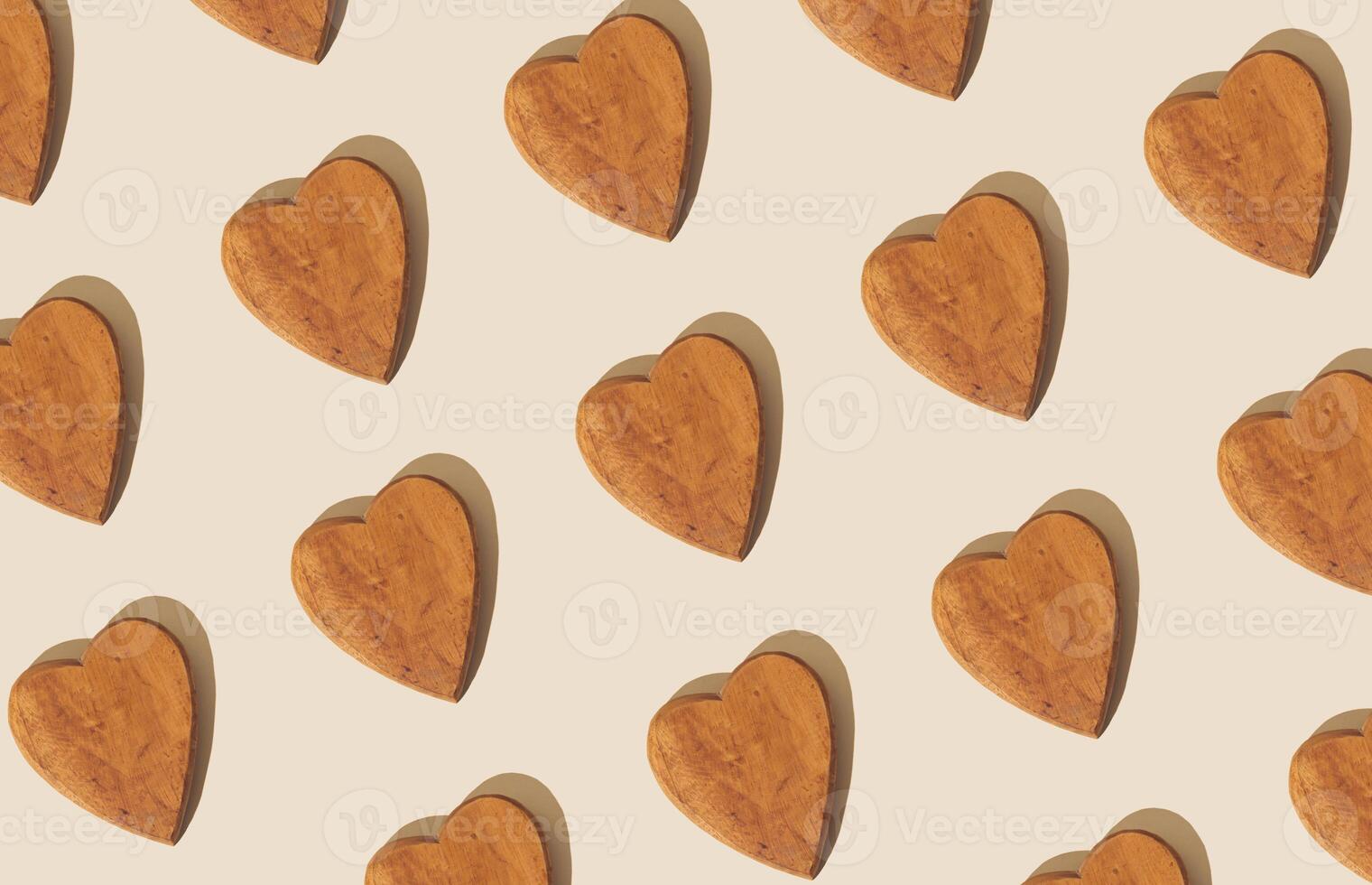 Creative pattern composition made with wooden hearts on pastel beige background. Minimal concept. Trendy love pattern background idea. Flat lay. photo