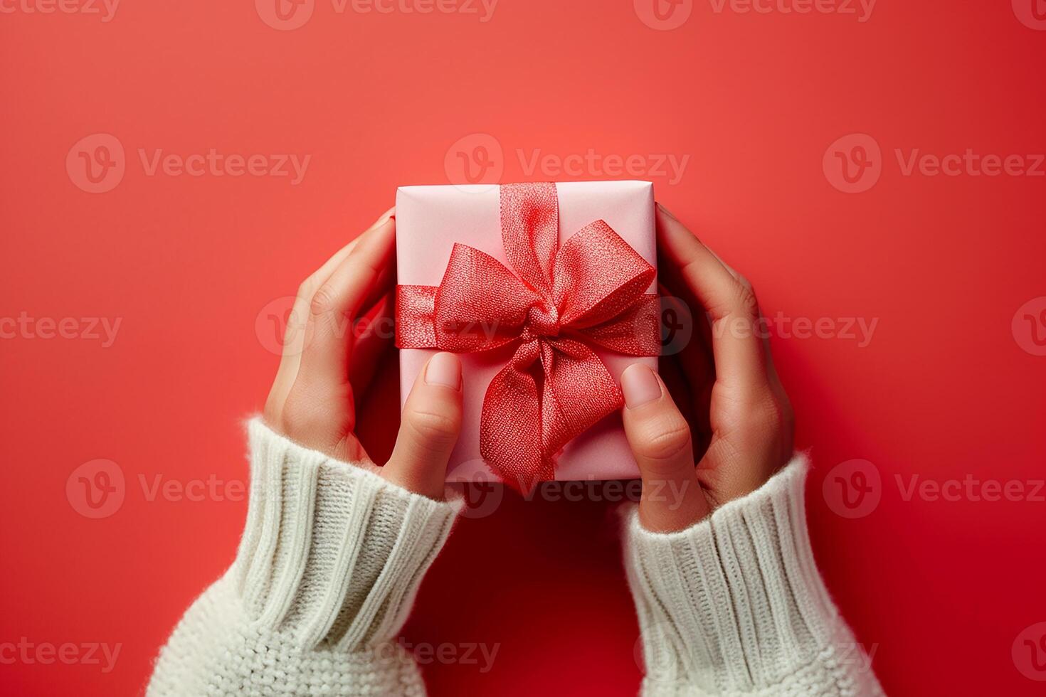 AI generated A woman hands hold a gift on a red and pink pastel table from above. It is a flat lay setup perfect for birthdays or weddings photo