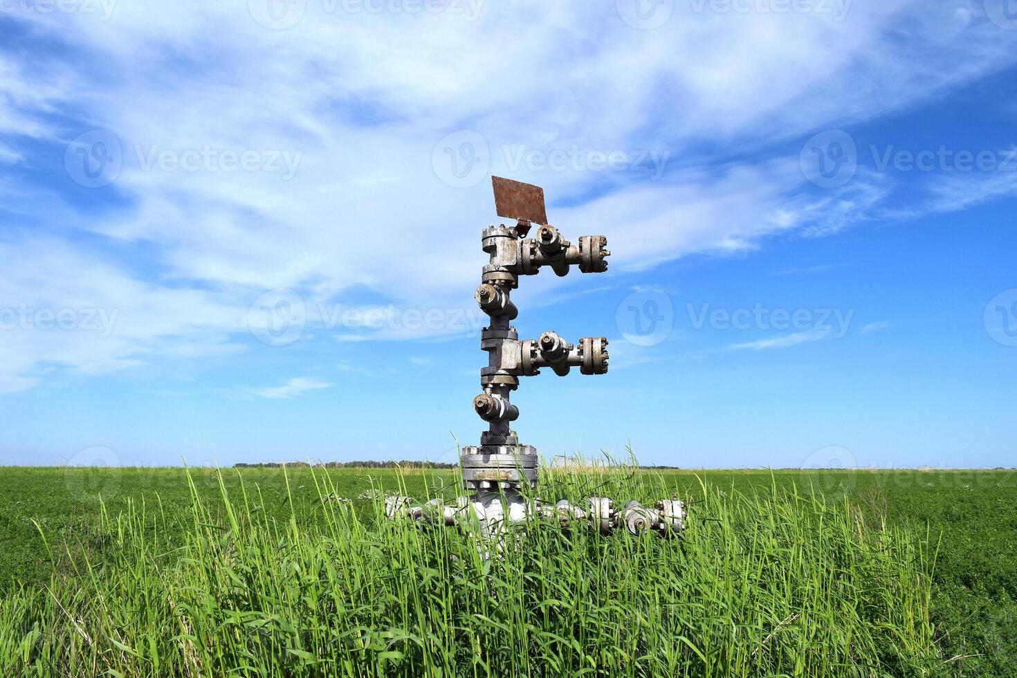 Canned oil well against the sky and field photo