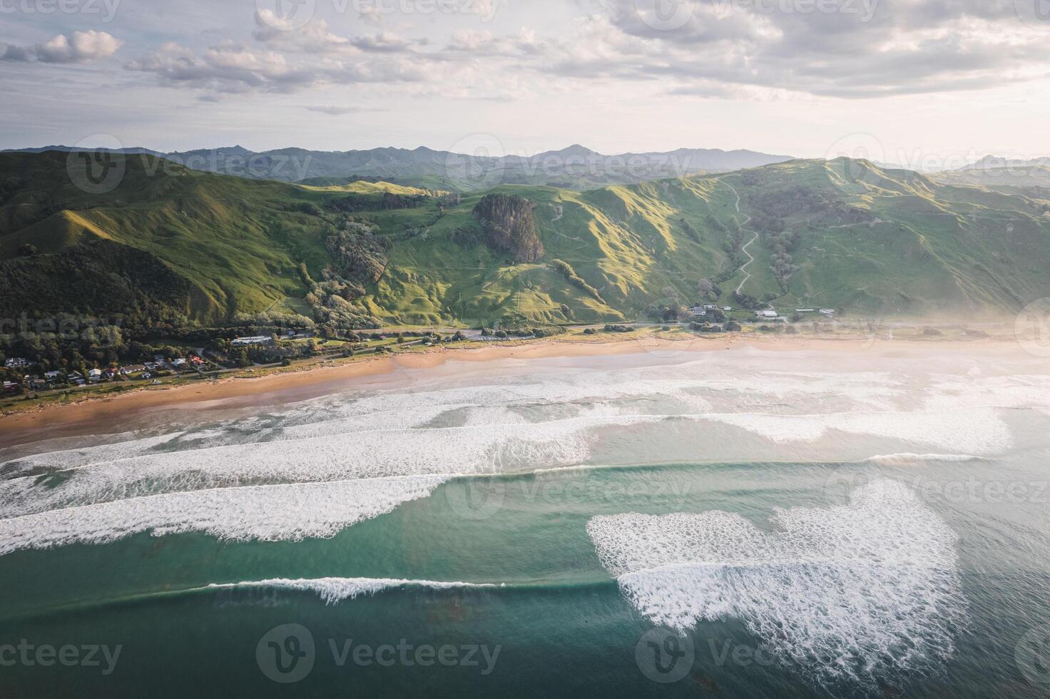 Aerial view on a small beach surrounded by rocks and forest. Coromandel, New Zealand photo