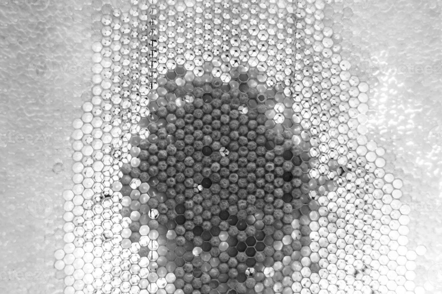 Drop of bee honey drip from hexagonal honeycombs filled with golden nectar photo