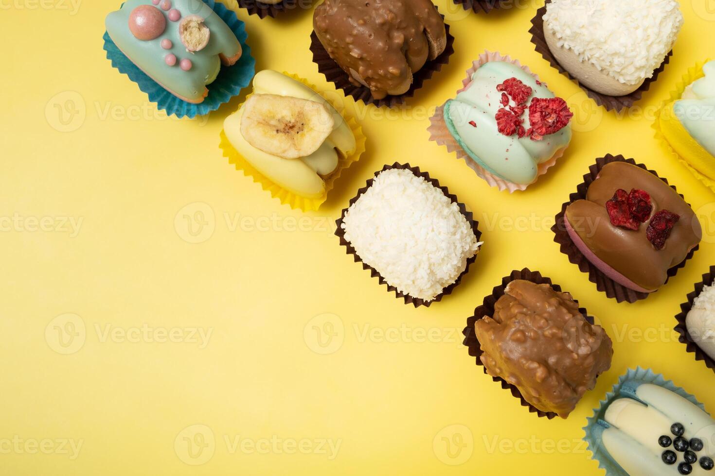 Set of different macaroons on yellow background top view, flat lay photo