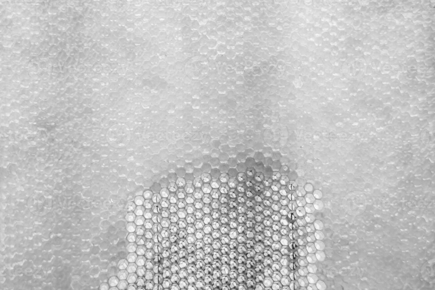 Drop of bee honey drip from hexagonal honeycombs filled with golden nectar photo
